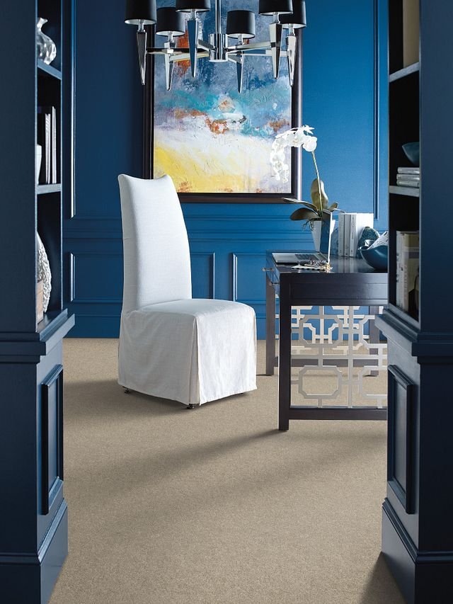 white chair in a room with blue walls and brown carpet
